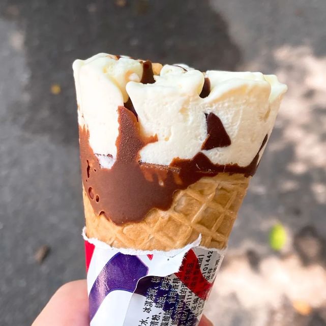 的香草冰淇淋上顶着香脆花生碎,伴随着香浓巧克力,底部还有酥脆甜筒