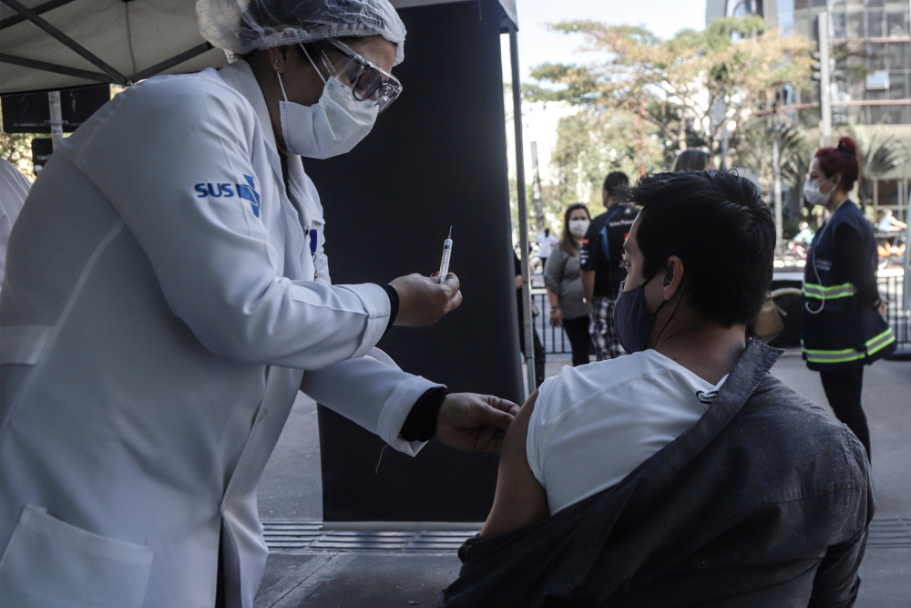 7月25日,巴西圣保罗市医护人员在给一名男子接种疫苗