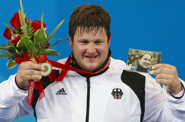 奥运会上的感人时刻带着亡妻照片领奖的奥运冠军