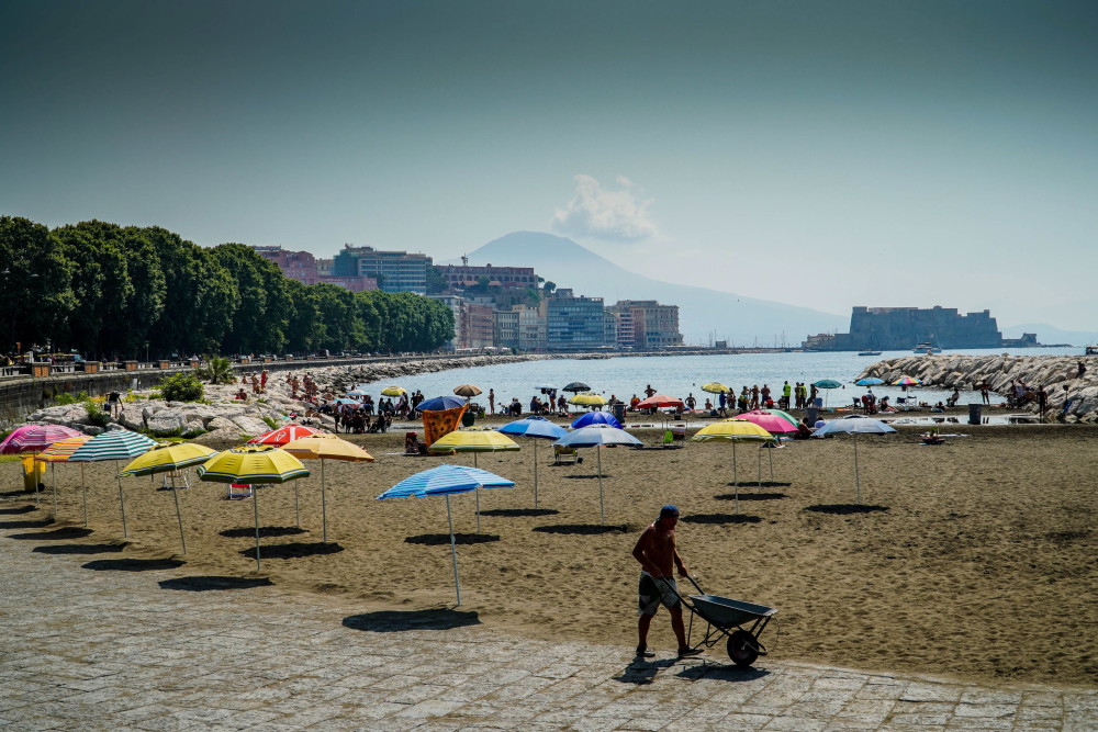 7月24日,人们在意大利那不勒斯的海边休闲游玩.       新华社/欧新