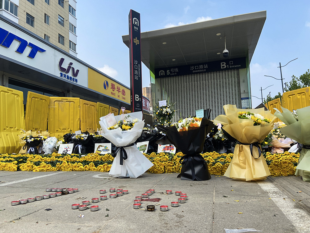 现场郑州地铁5号线站前民众献花悼念遇难者