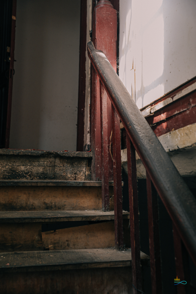 木质的楼梯踏上去咯吱作响,楼道缝隙里长出青苔,整个楼道背部暗黑无光