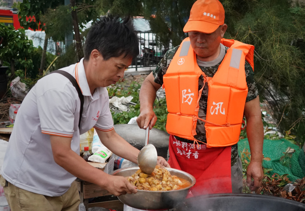 7月28日,卫辉市明珠花园小区居民在为救援人员准备午饭