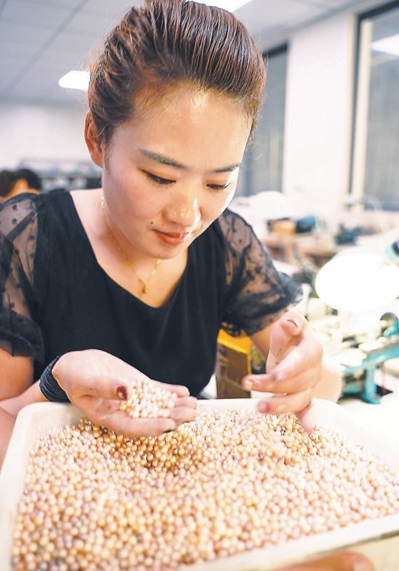 7月23日,在颍上县古城镇大赵村珍珠养殖基地的加工厂里,工人给珍珠