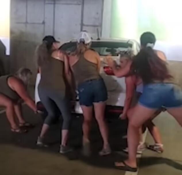 停车位被停歪的汽车阻挡 美国5名女子抬起汽车摆正
