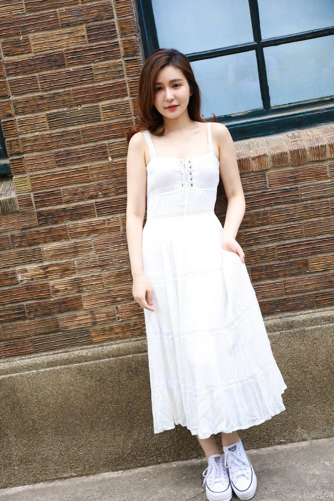 白色吊带裙飘逸有型,胸前抽绳的系带设计吸睛时尚