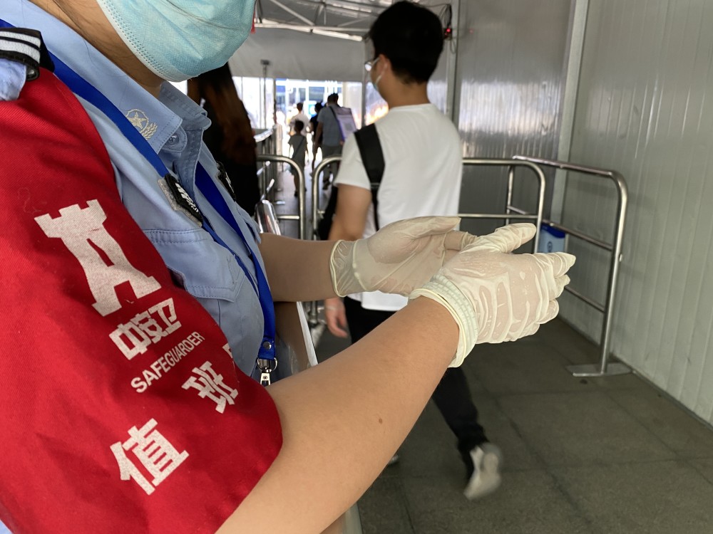 高温下的火车站测温员:每天查验上万人,手套里全是汗水