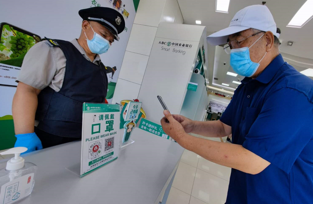 疫情防控不放松餐馆银行超市测温扫描后再进入