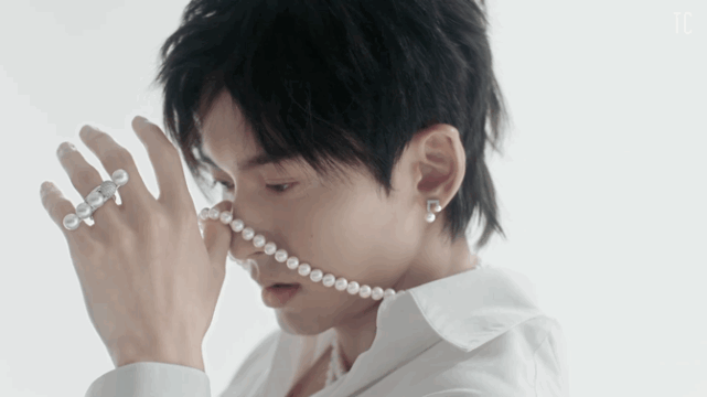 照片中,张哲瀚身穿白衬衫,颈部与手指被珍珠和钻石所点缀,还佩戴镣