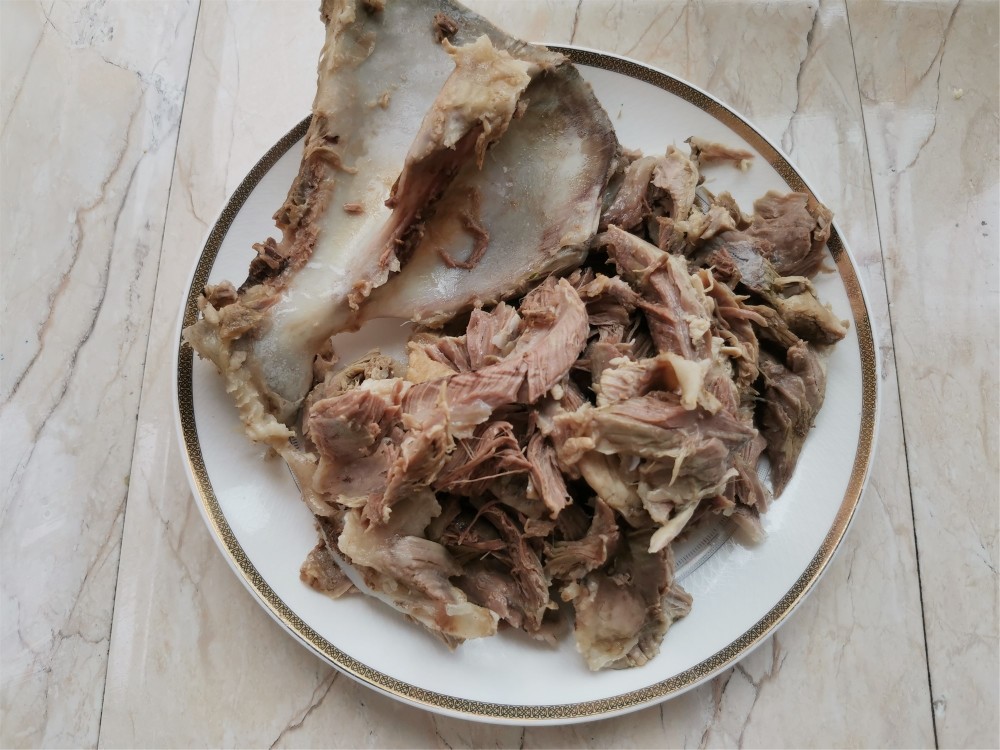 把猪骨头上大块的肉撕下来,难撕的部位,用刀把肉剔下来,再把猪肉撕成