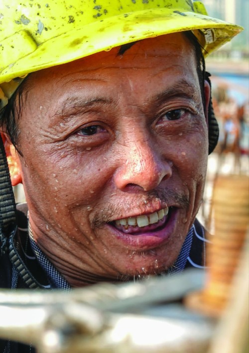 拧螺丝时挥汗如雨.西河滨河路建设项目工人"全副武装"焊接.