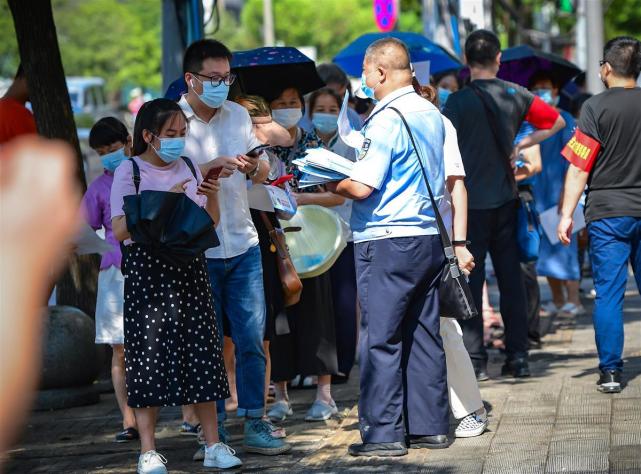 核酸檢測隊伍中有位發傳單的警察