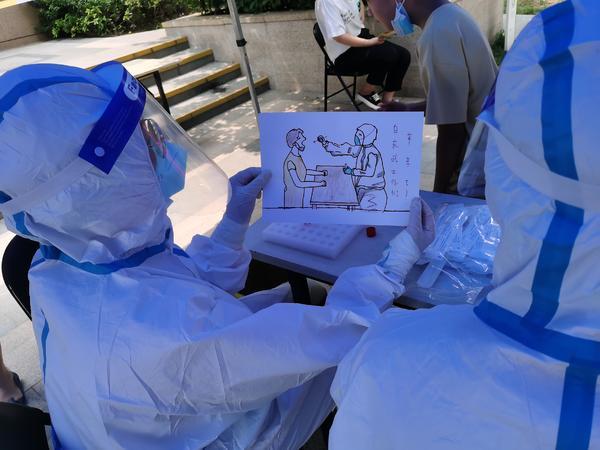 郑州抗疫温暖瞬间:萌娃画下医生为市民做核酸检测的场景,并写上"你们