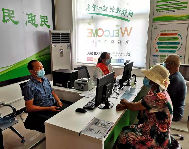 图为服务人员正在为群众提供政策咨询,办理业务,引导购物.