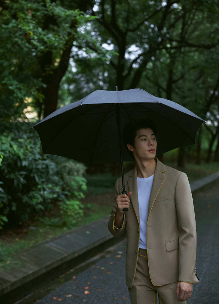 许光汉驼色西装展现帅气绅士范撑伞回眸氛围感十足