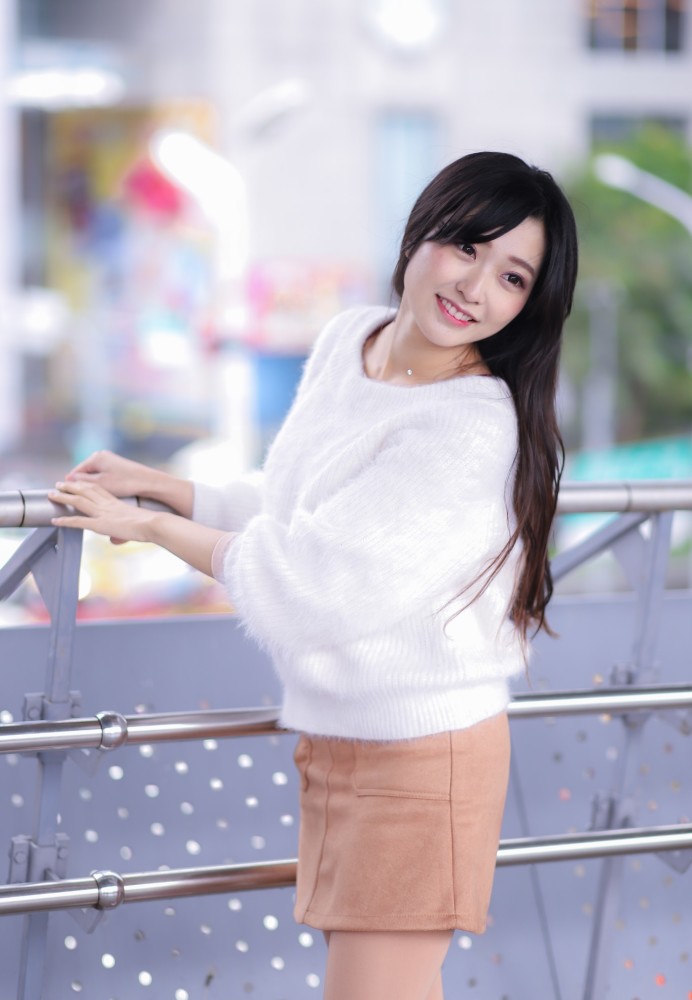 美女身着米色西服短裙搭配出精致的造型展示出女人柔和的美