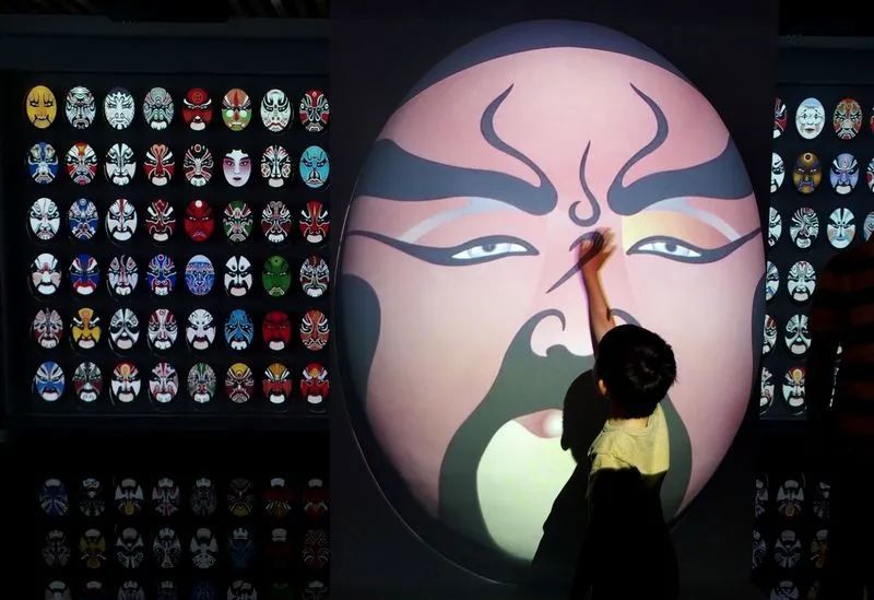 观众在"上海非物质文化遗产保护实践展"的"数字非遗"展区了解京剧脸谱