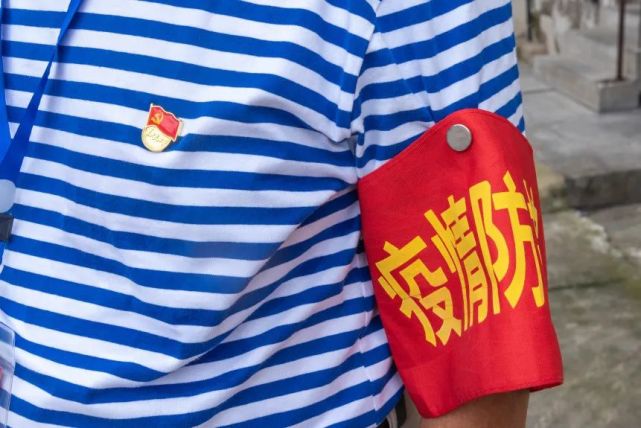 党徽熠熠生辉有行程码和健康码的二维码在他胸前挂着的牌子上左臂的