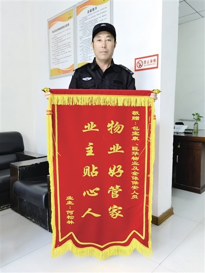 来到小区物业办公室,将锦旗送到小区保安包宝泉的手中,并一再感谢他