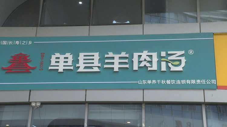 在银荷大厦这家店的招牌上,能清楚地看到"单县羊肉汤"注册商标的标志.