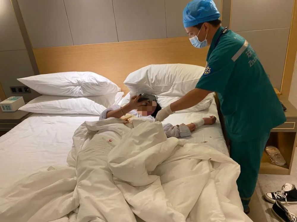 李女士则卧躺在床上,手腕处被利器割开的伤口正在流血.