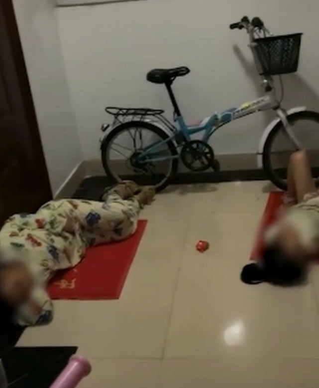 已经很晚了,两个孩子就分别躺在门口的地垫上,身体因为寒冷缩成一团