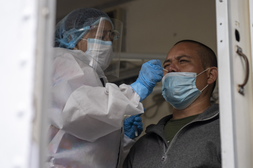 8月25日,一名医务人员在危地马拉首都危地马拉城进行新冠检测取样.