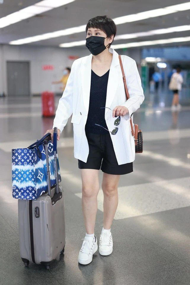 张凯丽活成了"60后骄傲",白西装配黑色内搭干净利落,减龄洋气