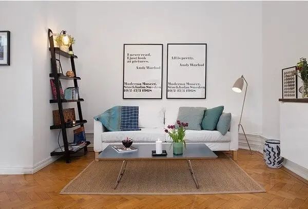 沙发区隐藏在凹型墙内,拥有一片静谧天地,靠墙还有一个梯形柜,加一盏