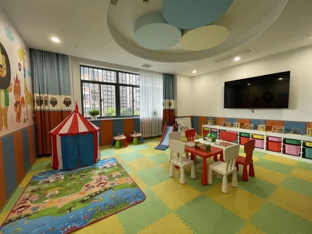 小屋内铺着彩色的地垫,桌椅也是根据幼儿的身高定制的.