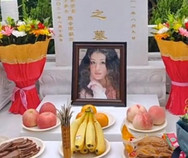 于月仙墓碑遗照公开,墓碑上面刻10个大字,鲜花和水果摆在面前