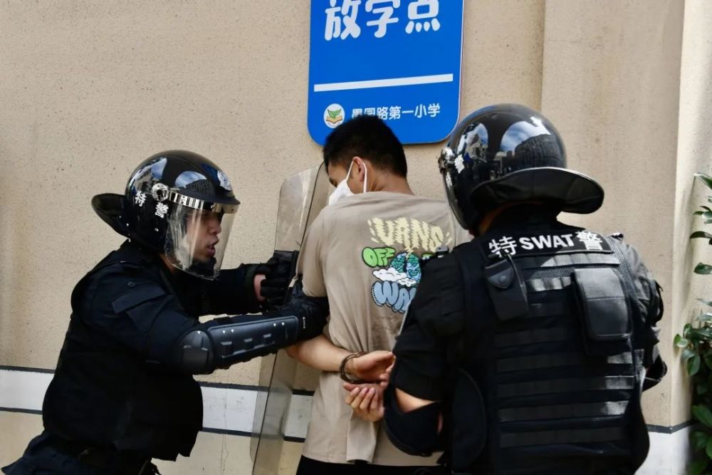 警告可疑人员放下武器,手持警棍继续制止其闯入校园