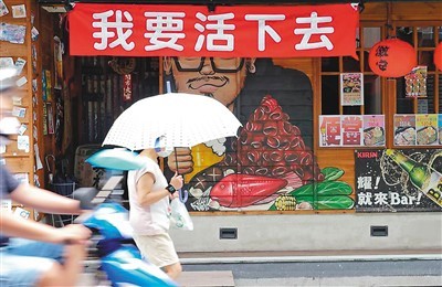 台北市街头一家餐厅,因疫情冲击生意惨淡,在店门口挂上"我要活下去"的