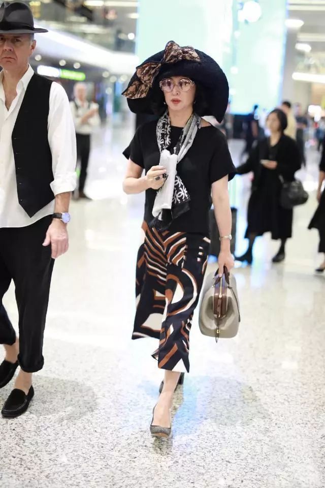 54岁金星穿高跟鞋高调走机场,开叉裙露出粗壮腿型,青筋凸起明显_腾讯