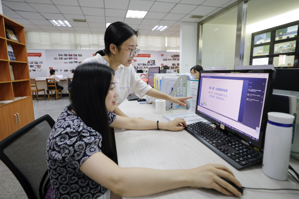 9月1日,成都七中"网课班"高一学生在教室门口的显示屏上查看课表及