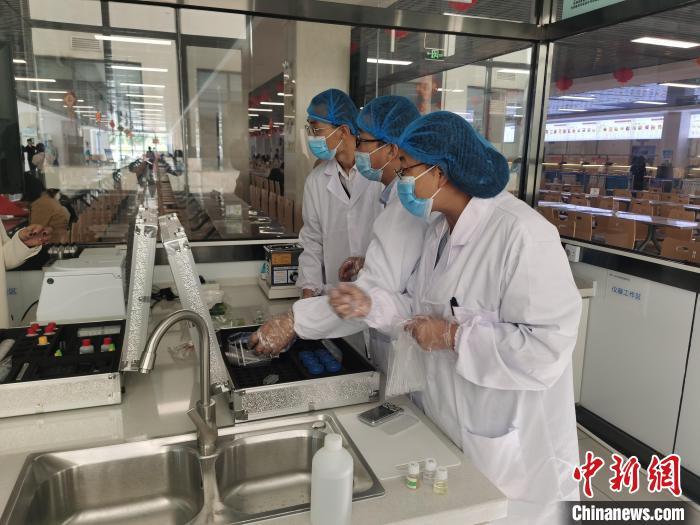 图为食品安全检测员正在校园食品快速检测室内进行快速检测.