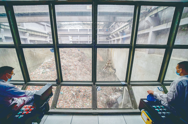 当天,在与垃圾池只有一块玻璃之隔的垃圾吊控制室内,两名工作人员远程