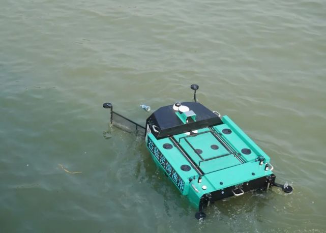 与会人员现场观摩水面救生机器人救援演练,无人船水漂垃圾清理
