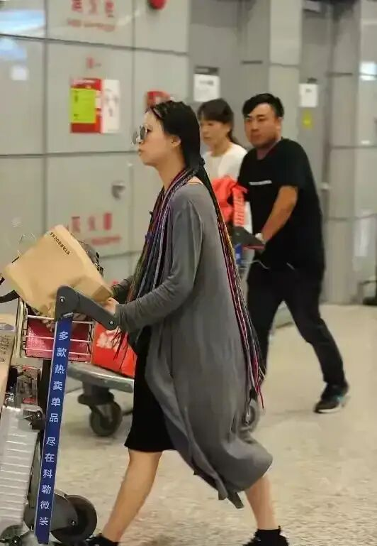 22岁小彩旗机场近照,暗色穿搭满头编发,跟以往小仙女形象大不同