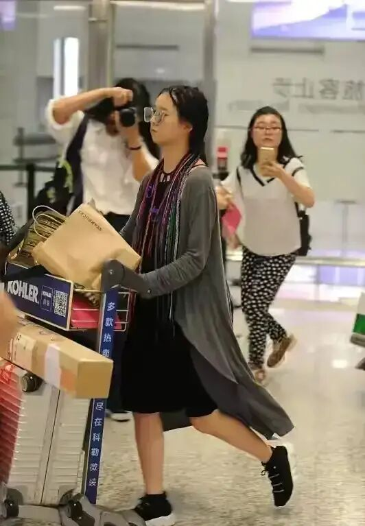 22岁小彩旗机场近照,暗色穿搭满头编发,跟以往小仙女形象大不同