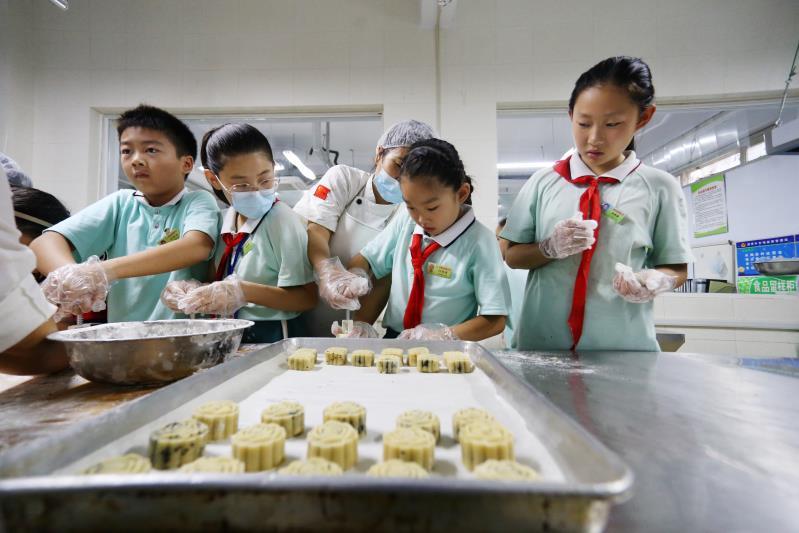 组图小学生做月饼喜洋洋迎中秋