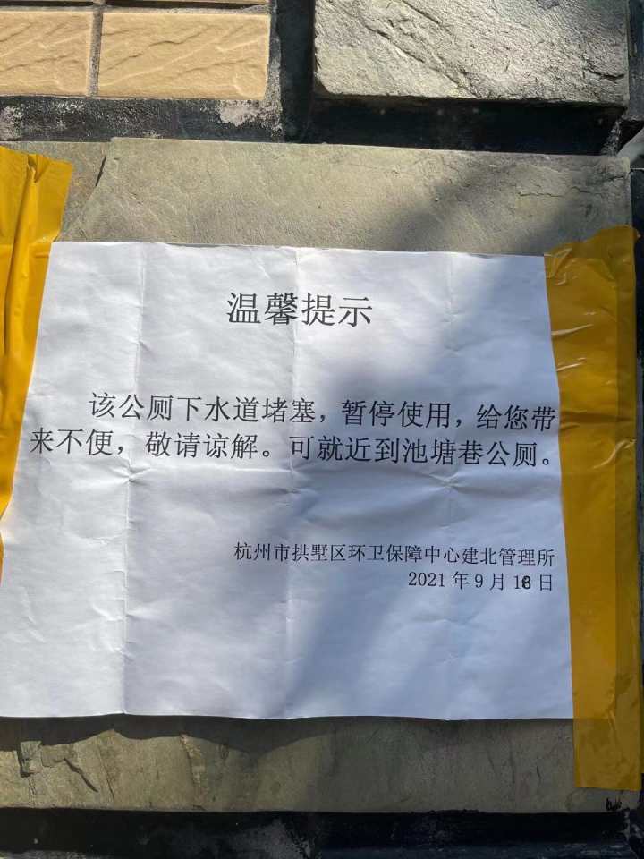上面写着:该公厕下水道堵塞,暂停使用,给您带来不便,敬请谅解.