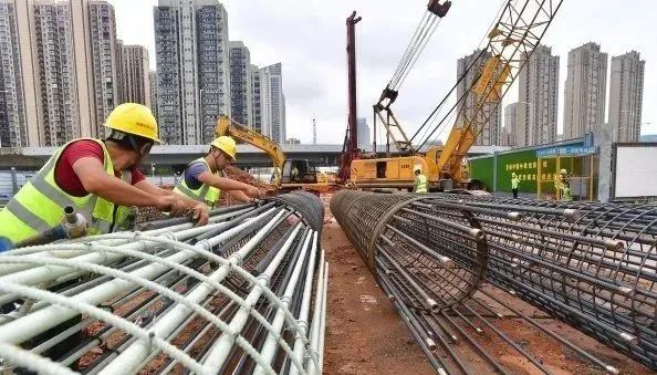 工人正在将用于围护桩基的玻璃纤维筋笼与钢筋笼连接在一起.