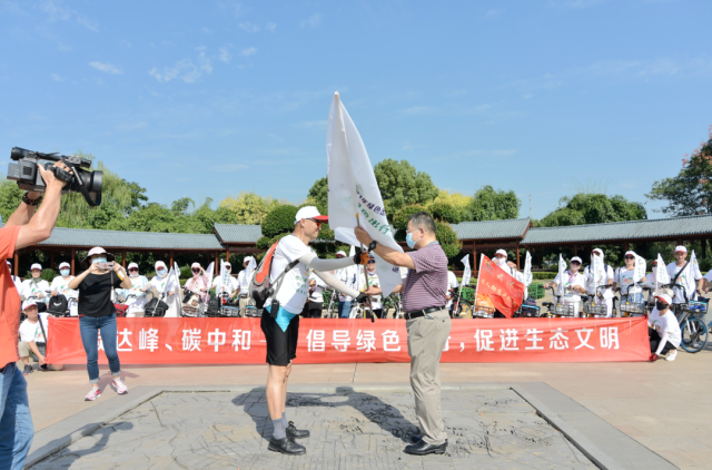 活动现场,武汉市交通运输局相关负责人为本次绿色骑行领队彭树才授旗