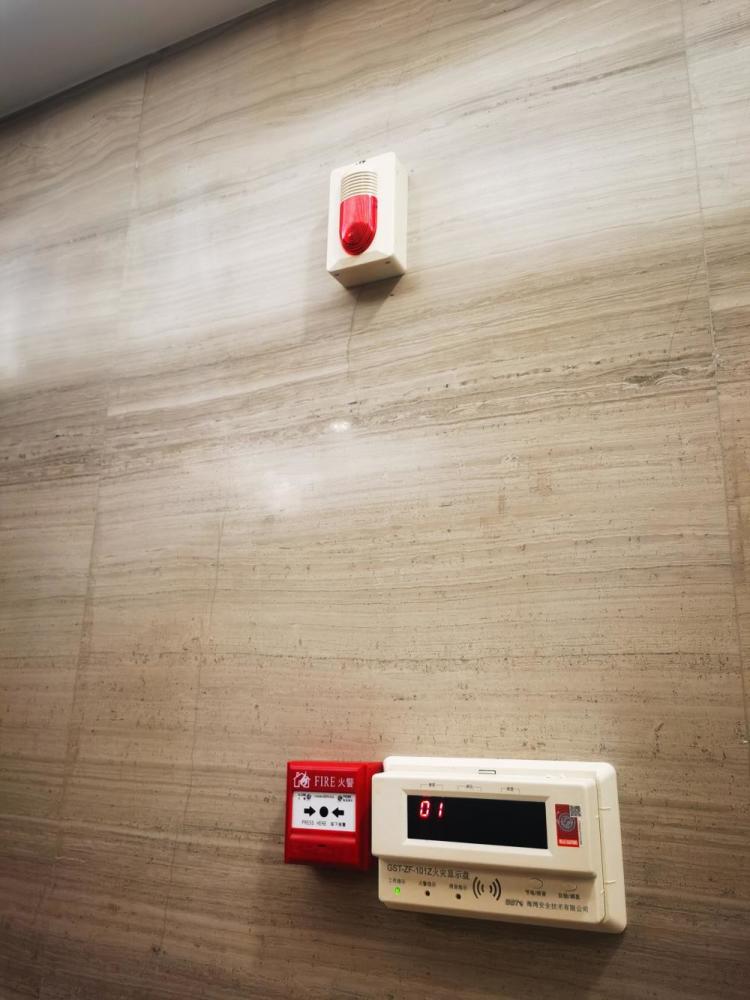 器就安装在楼道的墙上,是一个白色长方形盒子,标着"火灾显示盘"字样