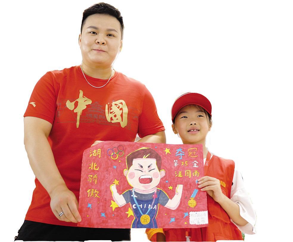 来自杨岔路小学205班的小记者陈嘉祺,给汪周雨姐姐送来绘制的漫画.