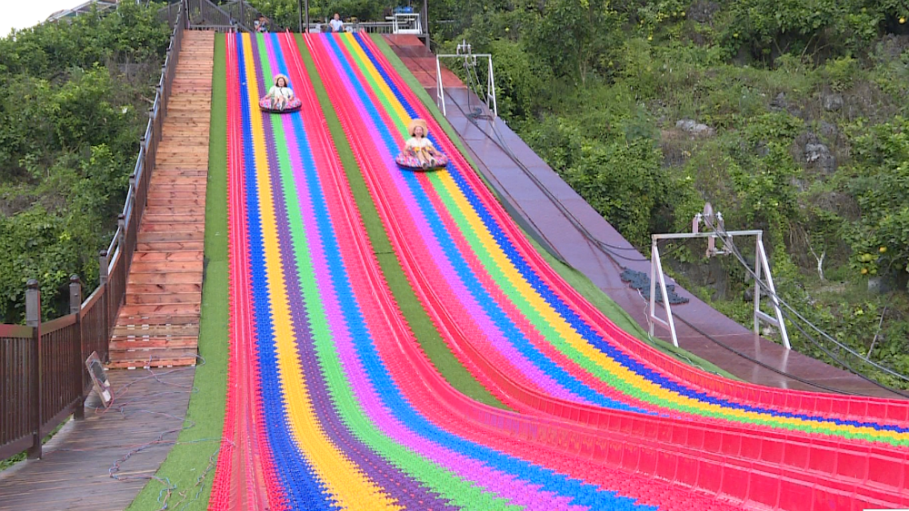 的滑道镶嵌在草坪中,两旁是茂密的树林,彼此交映,像极了山间的"彩虹"
