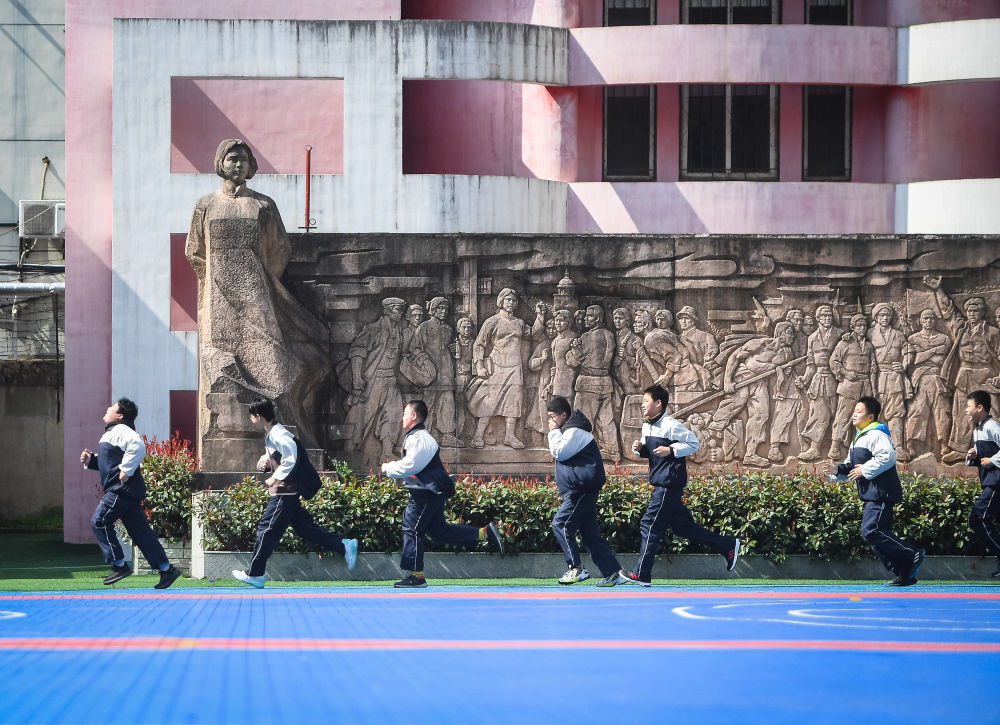 2021年3月5日,武汉市二十一(警予)中学学生从向警予烈士塑像前跑过.