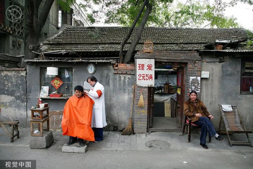 2007年,宣南文化胡同区,一宅院前的理发摊 张恺欣/视觉中国好些老北京