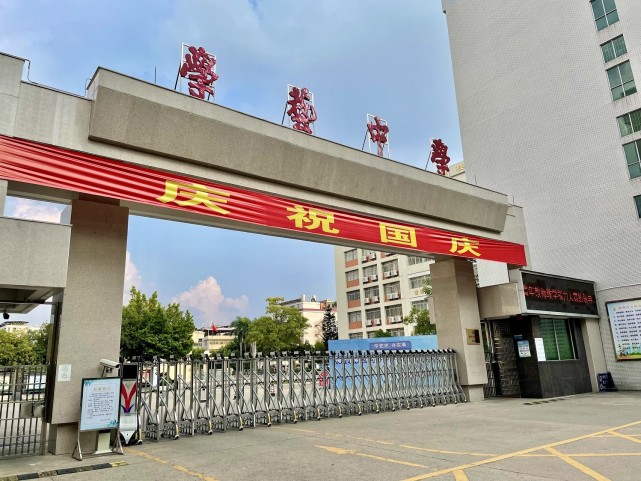 梅江区学艺中学大门处悬挂横幅,庆祝国庆.